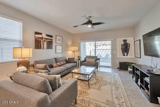 living room featuring ceiling fan and a healthy amount of sunlight