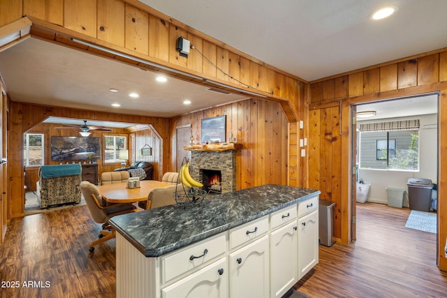 3384 Turkey Run, Overgaard, AZ 85933 - kitchen with a stone fireplace, wooden walls, open floor plan, dark wood finished floors, and ceiling fan