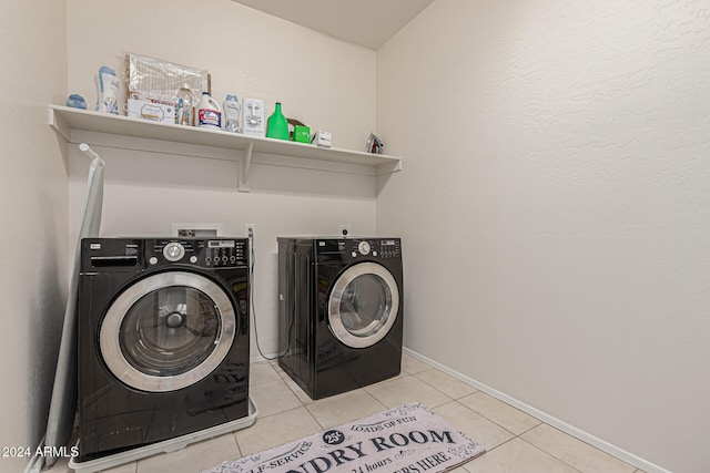 laundry area with washing machine and dryer and light tile patterned floors