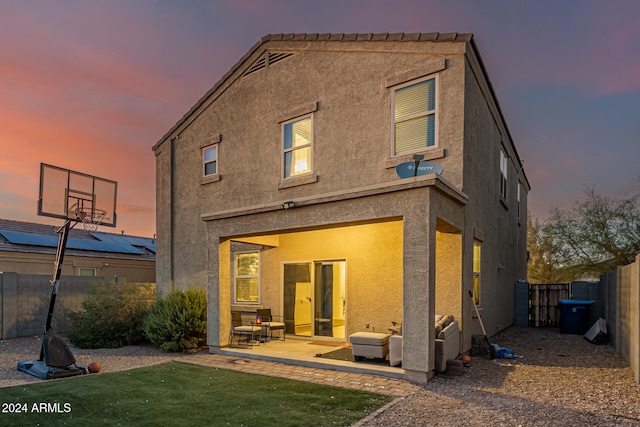 back house at dusk with a patio area