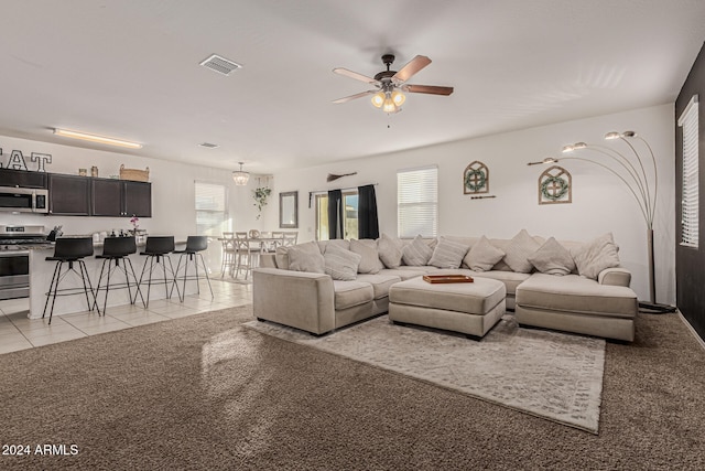 living room featuring light carpet and ceiling fan