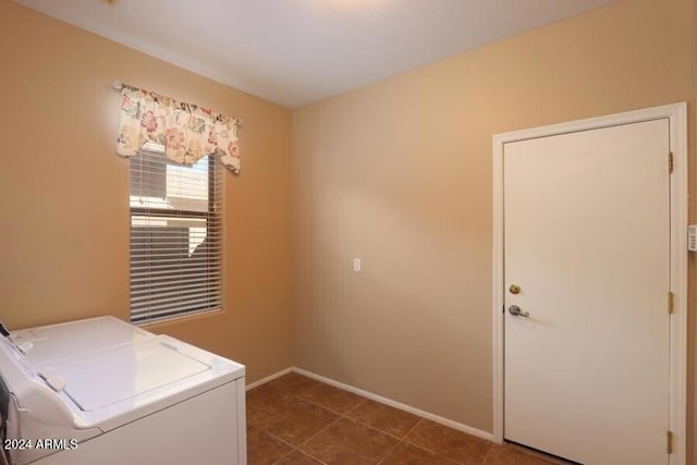 laundry room featuring washer and dryer and dark tile patterned floors