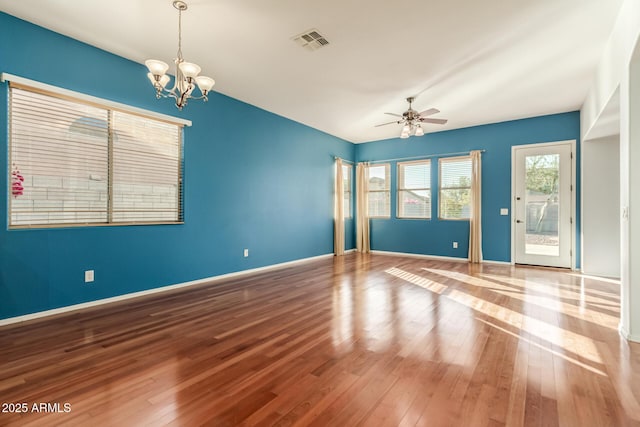 empty room with ceiling fan with notable chandelier and wood-type flooring