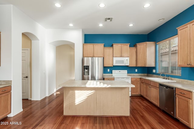 kitchen with a center island, sink, dark wood-type flooring, light brown cabinets, and stainless steel appliances