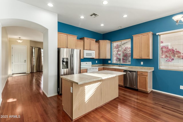 kitchen featuring appliances with stainless steel finishes, sink, light brown cabinets, and a kitchen island