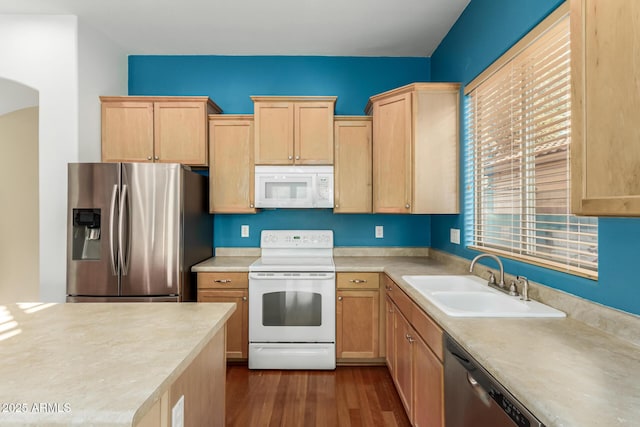 kitchen with appliances with stainless steel finishes, sink, light brown cabinets, and dark hardwood / wood-style floors