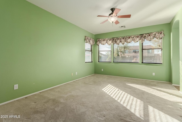 carpeted spare room with ceiling fan