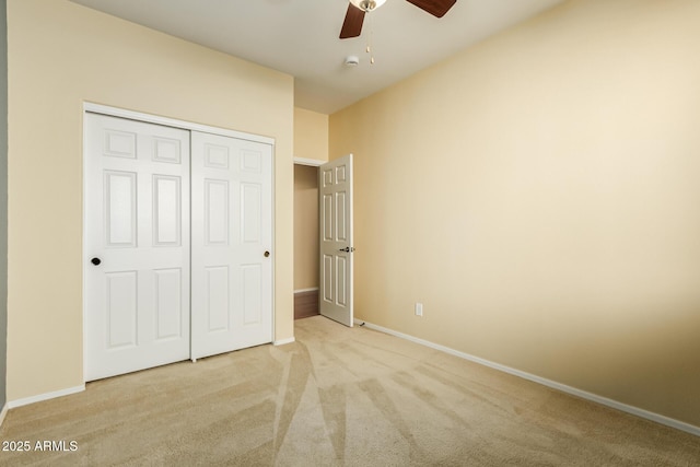 unfurnished bedroom with a closet, light colored carpet, and ceiling fan