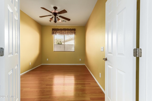 empty room with ceiling fan and wood-type flooring