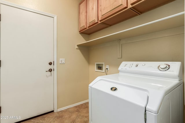 washroom featuring light tile patterned floors, washing machine and clothes dryer, and cabinets