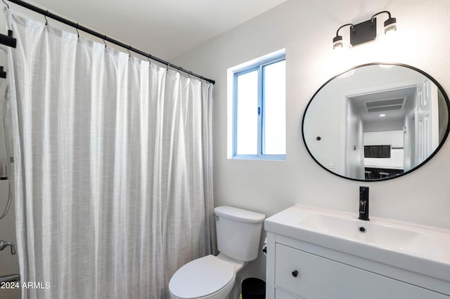 full bathroom featuring toilet, curtained shower, and vanity