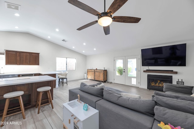 living room with light hardwood / wood-style flooring, french doors, ceiling fan, and vaulted ceiling