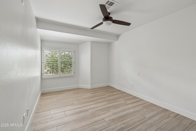 empty room with baseboards, ceiling fan, visible vents, and light wood-style floors