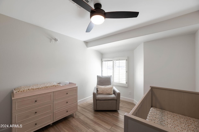 bedroom featuring light wood finished floors, a ceiling fan, and baseboards