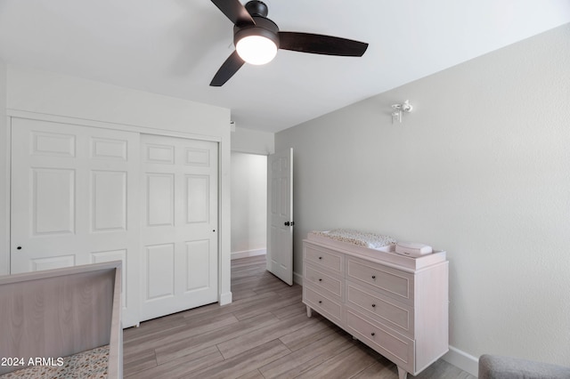 bedroom featuring light wood-style floors, a closet, baseboards, and a ceiling fan