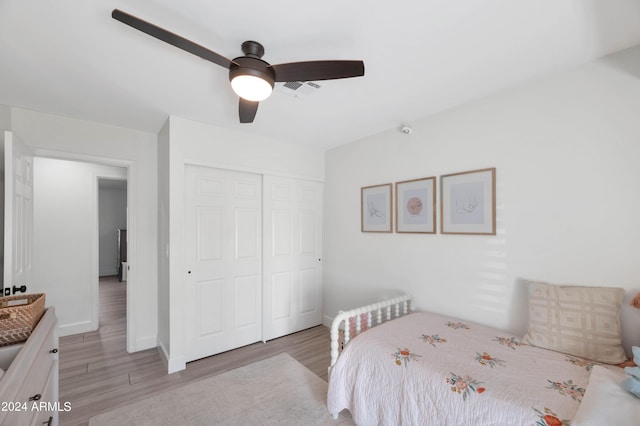 bedroom featuring light wood-style floors, a closet, ceiling fan, and baseboards