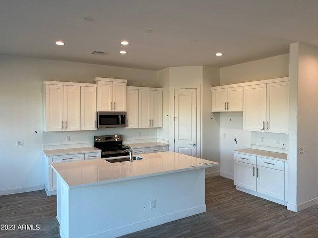 kitchen with a center island with sink, dark hardwood / wood-style floors, white cabinets, and appliances with stainless steel finishes