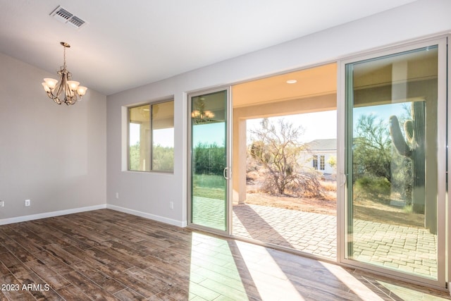 entryway featuring hardwood / wood-style flooring and a chandelier