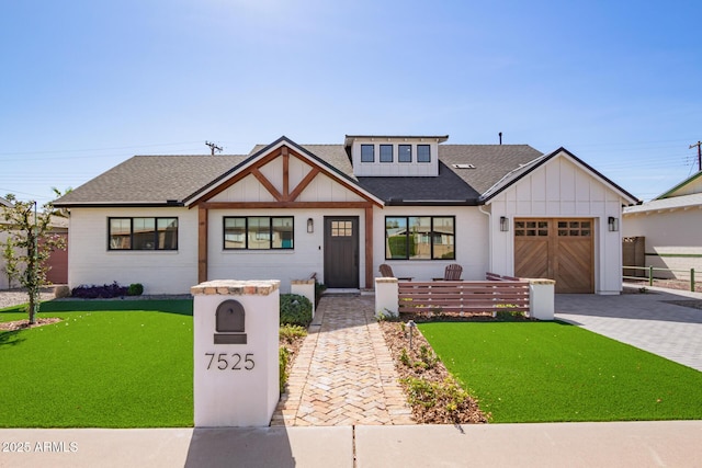 view of front of house featuring decorative driveway, a shingled roof, board and batten siding, a garage, and a front lawn