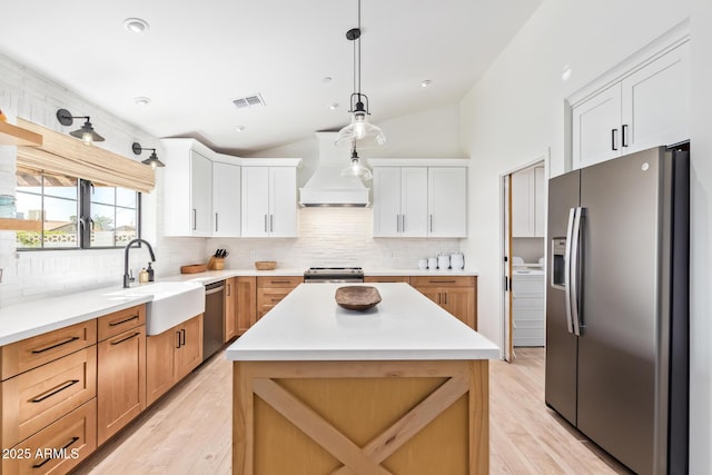 kitchen with light countertops, visible vents, appliances with stainless steel finishes, vaulted ceiling, and a sink