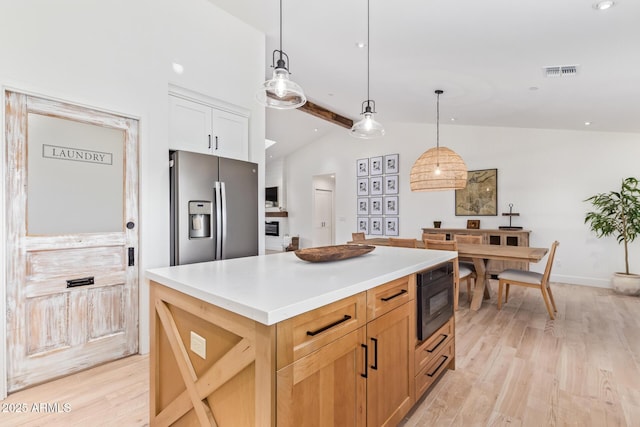 kitchen with vaulted ceiling with beams, stainless steel refrigerator with ice dispenser, visible vents, light wood-type flooring, and black microwave