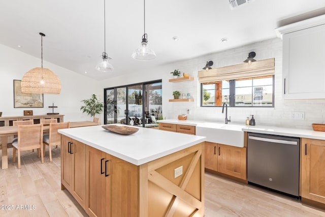 kitchen with decorative backsplash, lofted ceiling, a center island, stainless steel dishwasher, and a sink