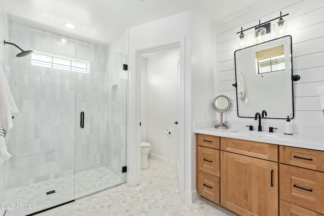 full bath with a stall shower, baseboards, vanity, and toilet