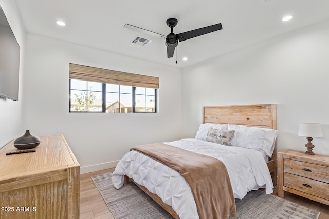 bedroom with baseboards, wood finished floors, visible vents, and recessed lighting