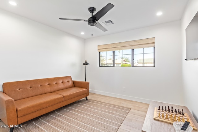 living room with recessed lighting, visible vents, baseboards, and wood finished floors