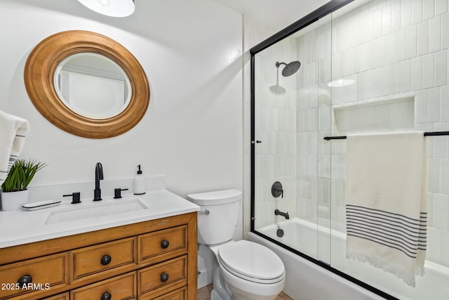 bathroom featuring bath / shower combo with glass door, vanity, and toilet