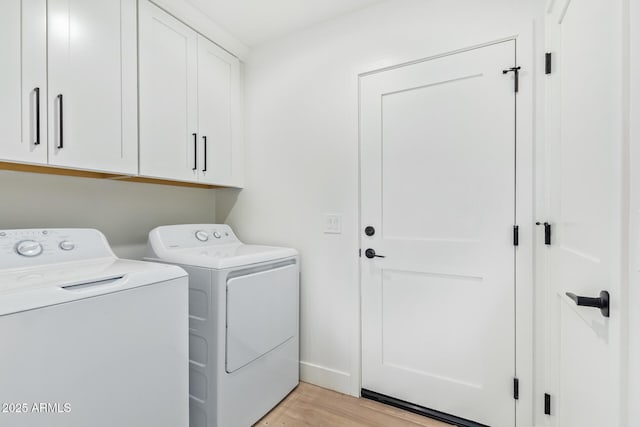 laundry area with light wood-type flooring, cabinet space, baseboards, and washing machine and clothes dryer