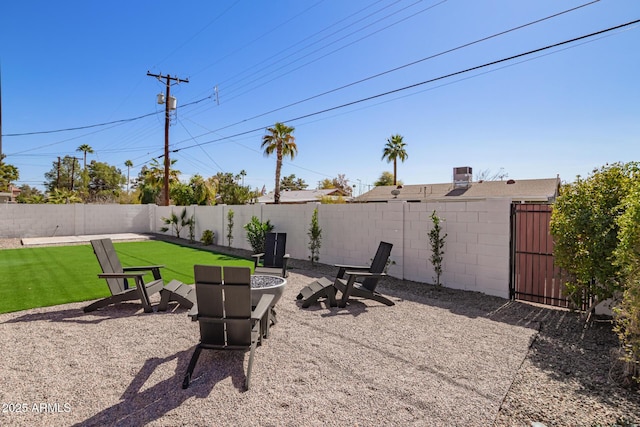 view of yard featuring an outdoor fire pit, a patio area, and a fenced backyard