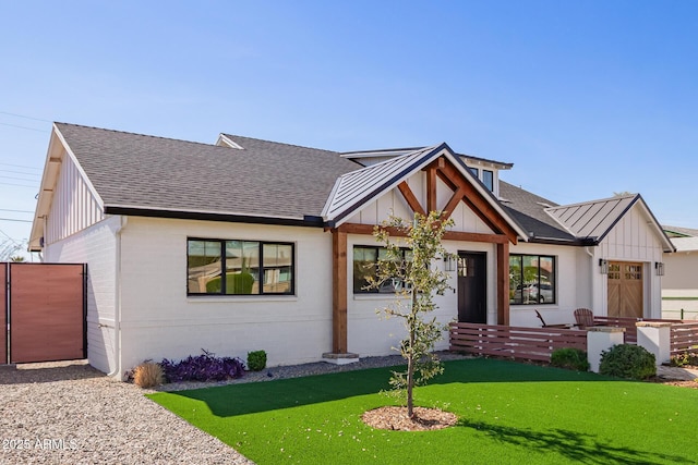 view of front facade with a front yard, board and batten siding, and roof with shingles