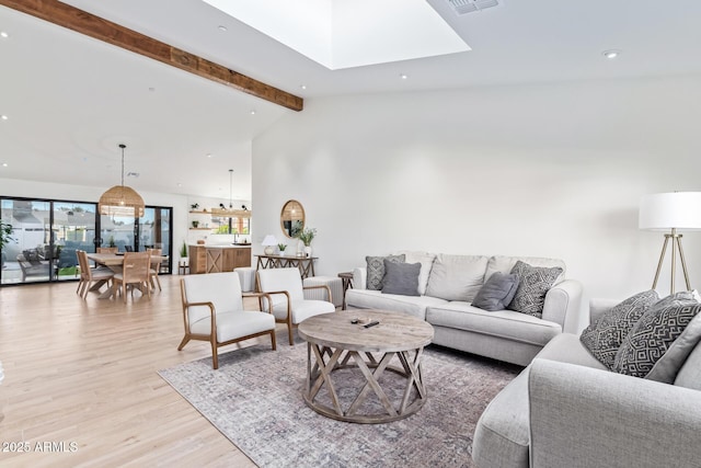 living room featuring high vaulted ceiling, recessed lighting, a skylight, light wood-style floors, and beamed ceiling