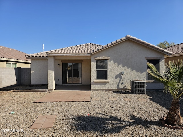 back of property with cooling unit and a patio