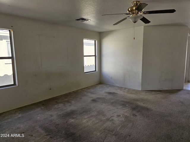 spare room with a textured ceiling, carpet floors, and ceiling fan