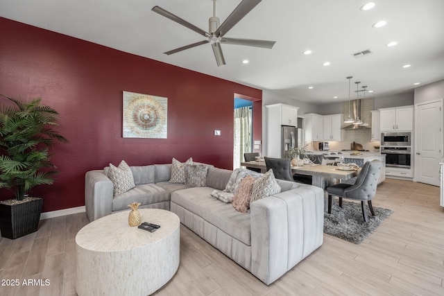 living room with ceiling fan and light hardwood / wood-style floors