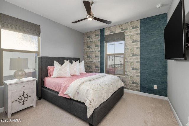 bedroom with ceiling fan, light carpet, and multiple windows