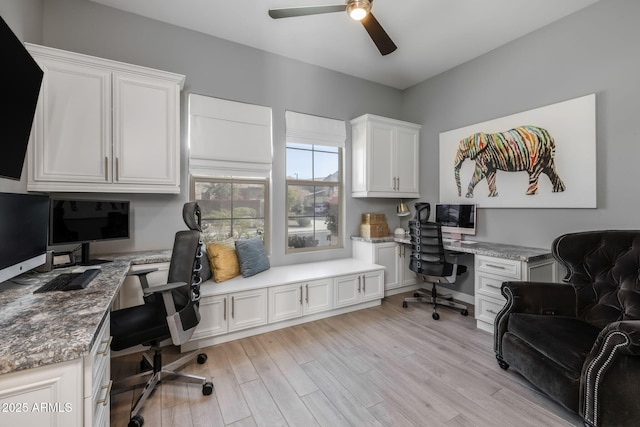 home office featuring built in desk, light hardwood / wood-style floors, and ceiling fan