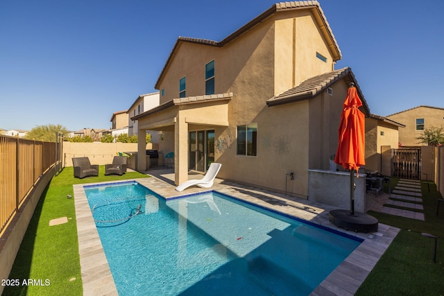 back of house with an outdoor living space, a patio, and a fenced in pool