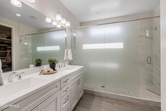 bathroom featuring vanity and a shower with door