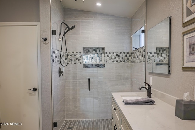 bathroom featuring walk in shower, vanity, and vaulted ceiling