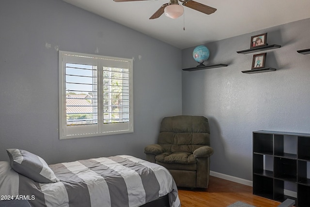 bedroom with hardwood / wood-style flooring, ceiling fan, and lofted ceiling