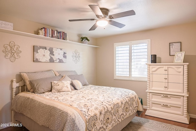 bedroom with ceiling fan and dark hardwood / wood-style flooring