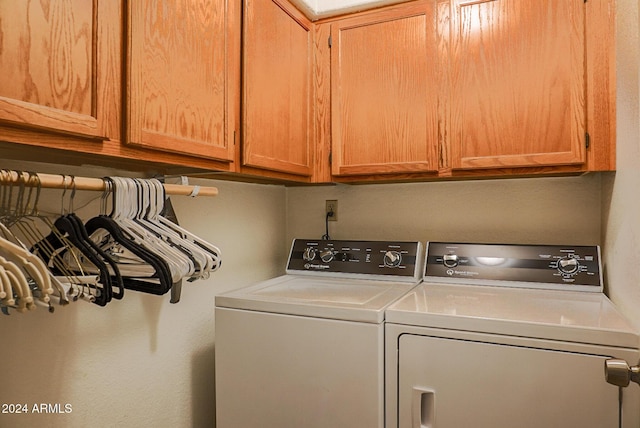 clothes washing area with cabinets and independent washer and dryer