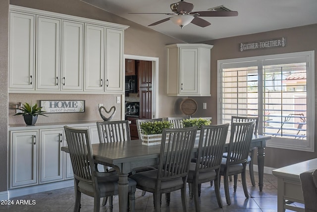 dining area with lofted ceiling, ceiling fan, and dark tile patterned floors