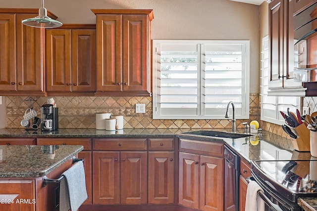 kitchen featuring tasteful backsplash, stainless steel dishwasher, sink, and dark stone countertops