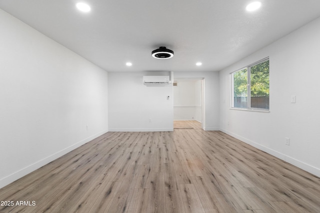 empty room featuring light hardwood / wood-style floors and a wall mounted AC