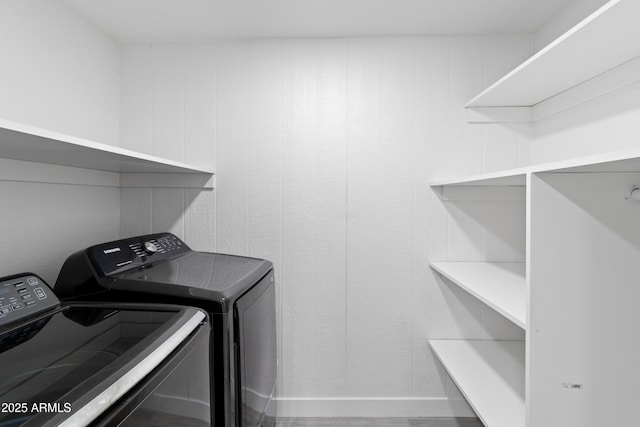 washroom featuring separate washer and dryer and wooden walls