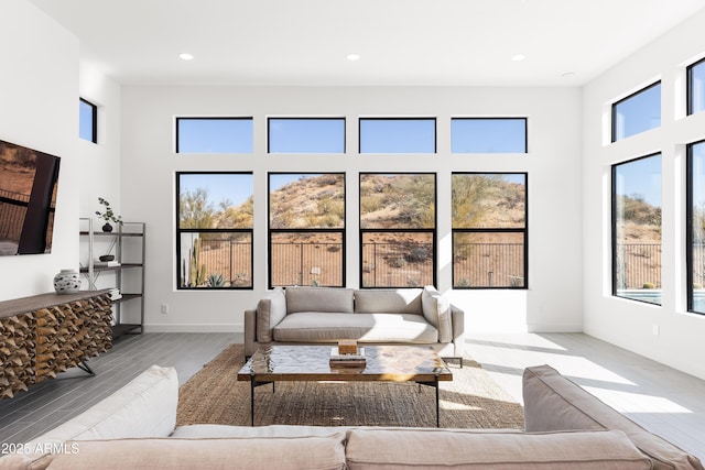 living room with a towering ceiling and light hardwood / wood-style flooring